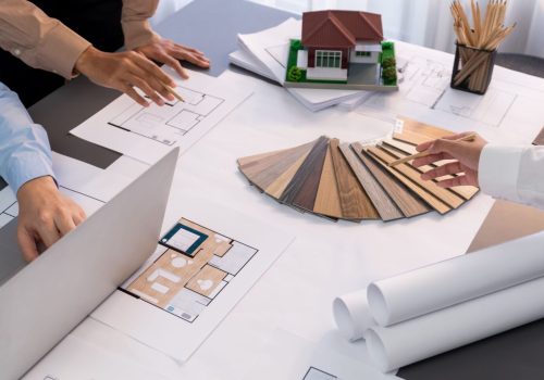 Group of interior designer team in meeting, discussing with engineer on interior design and planning for house project blueprint and model, choosing color sample and mood board materials. Insight