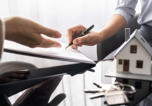 House model with agent and customer discussing for contract to buy, get insurance or loan real estate or property.